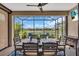 Covered and screened patio boasts seating, a dining table, and views of the community lake at 27467 Janzen Ct, Englewood, FL 34223