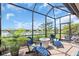 Enjoy outdoor living on the screened patio with Adirondack chairs and peaceful lake views at 27467 Janzen Ct, Englewood, FL 34223
