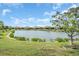 Picturesque pond surrounded by lush grass and landscaping, adding to the serene setting at 27467 Janzen Ct, Englewood, FL 34223