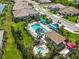 Aerial view of community pool with blue canopies, lounge chairs, spa, and well maintained landscaping at 27467 Janzen Ct, Englewood, FL 34223