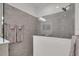 Frameless glass shower with grey tile surround and mounted shower head at 27467 Janzen Ct, Englewood, FL 34223