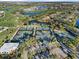 Aerial view of community tennis courts, golf course, lakes and residences in a beautiful, well-maintained neighborhood at 27467 Janzen Ct, Englewood, FL 34223
