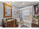 Stylishly designed bathroom with dark wood vanity, soaking tub, and framed mirror at 318 Venice East Blvd, Venice, FL 34293