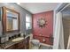 Nicely decorated bathroom featuring a dark wood vanity, decorative mirror, and tiled shower at 318 Venice East Blvd, Venice, FL 34293