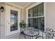 Cozy porch area with decorative table, chairs, and a patterned-glass door at 318 Venice East Blvd, Venice, FL 34293