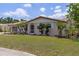 Charming single-story home with a well-manicured lawn, landscaped garden, and a welcoming screened front door at 318 Venice East Blvd, Venice, FL 34293