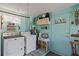 Bright laundry room with washer, dryer, utility sink, and storage with accents of blue walls at 318 Venice East Blvd, Venice, FL 34293