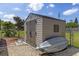 Backyard storage shed with gray doors and siding near a chain link fence and an upside-down canoe at 318 Venice East Blvd, Venice, FL 34293