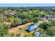 Aerial view showcases a treelined neighborhood and home with large, grassy yard near bay at 352 Glenwood Ave, Osprey, FL 34229
