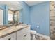 A modern bathroom with a stone-walled shower, large mirror, and a white vanity sink at 352 Glenwood Ave, Osprey, FL 34229