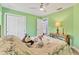 Cozy green bedroom with natural light, wood flooring and an open door to the hallway at 352 Glenwood Ave, Osprey, FL 34229