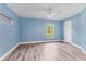 An empty bedroom with wood flooring, a ceiling fan, and light blue walls, providing a calm setting at 352 Glenwood Ave, Osprey, FL 34229