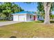 Charming home with a blue metal roof, a white exterior, and a red front door at 352 Glenwood Ave, Osprey, FL 34229