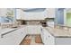 Well-lit kitchen with stylish backsplash, granite countertops, and white cabinets, perfect for cooking at 352 Glenwood Ave, Osprey, FL 34229