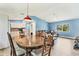 Open-concept living room featuring wood floors, a dining area, and a kitchen with white cabinetry at 352 Glenwood Ave, Osprey, FL 34229