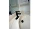 Close-up of a bathroom sink with a modern black faucet and cream colored countertops at 3851 Sterling Rd, Venice, FL 34293