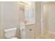 Bright bathroom featuring a vanity with cabinet storage, a mirror with lighting, and white toilet at 3851 Sterling Rd, Venice, FL 34293
