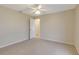 Empty bedroom with neutral carpet, ceiling fan, and a doorway to the hallway at 3851 Sterling Rd, Venice, FL 34293