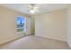 Cozy, carpeted bedroom with a large window offering a serene outdoor view and natural light at 3851 Sterling Rd, Venice, FL 34293