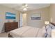 Bright bedroom with ocean-themed art, wood dresser, and white linens on the bed at 3851 Sterling Rd, Venice, FL 34293