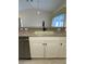 Well-lit kitchen featuring white cabinets, stainless steel dishwasher, and a double bowl sink at 3851 Sterling Rd, Venice, FL 34293