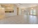 Open-concept living room with tile flooring, ceiling fan, and access to the kitchen and French doors leading outside at 3851 Sterling Rd, Venice, FL 34293