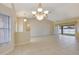 Spacious living room with tiled floors, a ceiling fan, and natural light from a sliding glass door at 3851 Sterling Rd, Venice, FL 34293