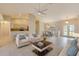 Staged living room with modern furniture, tile flooring, and an open view into the adjacent kitchen and dining area at 3851 Sterling Rd, Venice, FL 34293