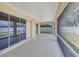 The covered patio includes a ceiling fan, screen and sliding glass doors looking out to the fenced backyard at 3851 Sterling Rd, Venice, FL 34293