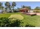Backyard features a putting green, a fire pit with seating, and an outdoor building with stairs at 409 Armada S Rd, Venice, FL 34285
