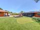 Spacious backyard featuring putting green, outdoor kitchen, and screened patio for relaxing outdoor living at 409 Armada S Rd, Venice, FL 34285
