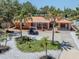 Exterior of a one-story home with a metal roof, mature landscaping, a long driveway, and an electric golf cart at 409 Armada S Rd, Venice, FL 34285