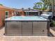Wonderful hot tub with water features sits on a paver patio with an outdoor kitchen nearby at 409 Armada S Rd, Venice, FL 34285