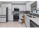 Bright kitchen features white cabinetry, stainless appliances, mosaic backsplash, and convenient pull-out drawers at 409 Armada S Rd, Venice, FL 34285