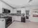 Bright kitchen features white cabinets, stainless appliances, mosaic backsplash, and an exterior door at 409 Armada S Rd, Venice, FL 34285