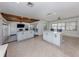 Open concept living area with beamed ceiling and tile floors open to the sunroom at 409 Armada S Rd, Venice, FL 34285