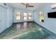 Bright living room with modern ceiling fan, sleek flooring, and views of the landscaped backyard at 409 Armada S Rd, Venice, FL 34285