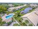 Aerial view of a condo complex featuring a community pool, lake, and well manicured lawns at 410 Mission E Trl # B, Venice, FL 34285