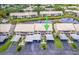 Aerial view of condo complex featuring lush landscaping, lake views, and convenient parking at 410 Mission E Trl # B, Venice, FL 34285