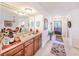Wet bar area with wood cabinetry, a mirrored backdrop, and a convenient sink, leading into dining area at 410 Mission E Trl # B, Venice, FL 34285