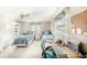 Bright bedroom with two twin beds, a ceiling fan, and a well-lit desk area for study or work at 410 Mission E Trl # B, Venice, FL 34285