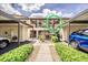 Condo with covered parking, well-maintained landscaping, and private entry stairs to the second floor at 410 Mission E Trl # B, Venice, FL 34285