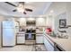 Functional kitchen featuring stainless steel appliances, white cabinets, and tile flooring for easy maintenance at 410 Mission E Trl # B, Venice, FL 34285
