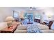 Cozy living room with comfortable seating, ceiling fan, and view of the outdoor balcony at 410 Mission E Trl # B, Venice, FL 34285