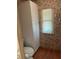 A bathroom with a toilet, window, and cabinet, all adorned with floral wallpaper at 417 Via Veneto, Venice, FL 34285