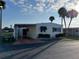 Charming mobile home with a covered carport and well-maintained landscaping at 417 Via Veneto, Venice, FL 34285