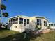 Bright mobile home with an enclosed porch and well-maintained lawn at 417 Via Veneto, Venice, FL 34285