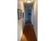 Long hallway with wood flooring and artwork on the walls at 417 Via Veneto, Venice, FL 34285