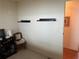 A spacious room with floating shelves, chair and black display unit at 417 Via Veneto, Venice, FL 34285