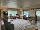 Cozy living room featuring wicker furniture, ceiling fan, and large windows with a water view at 417 Via Veneto, Venice, FL 34285